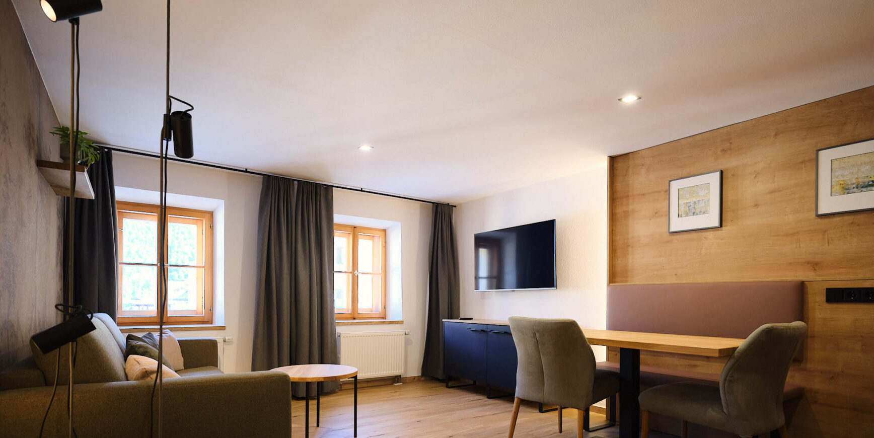 Ansicht des Wohnzimmers mit Tisch, Fernseher und Sofa