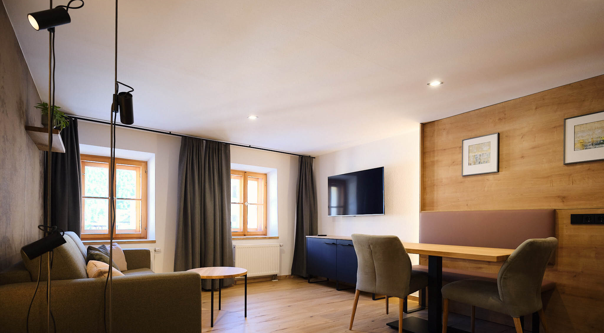 Ansicht des Wohnzimmers mit Tisch, Fernseher und Sofa