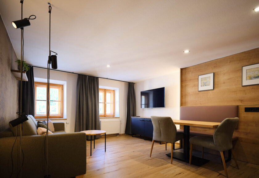 Ansicht des Wohnzimmers mit Tisch, Fernseher und Sofa