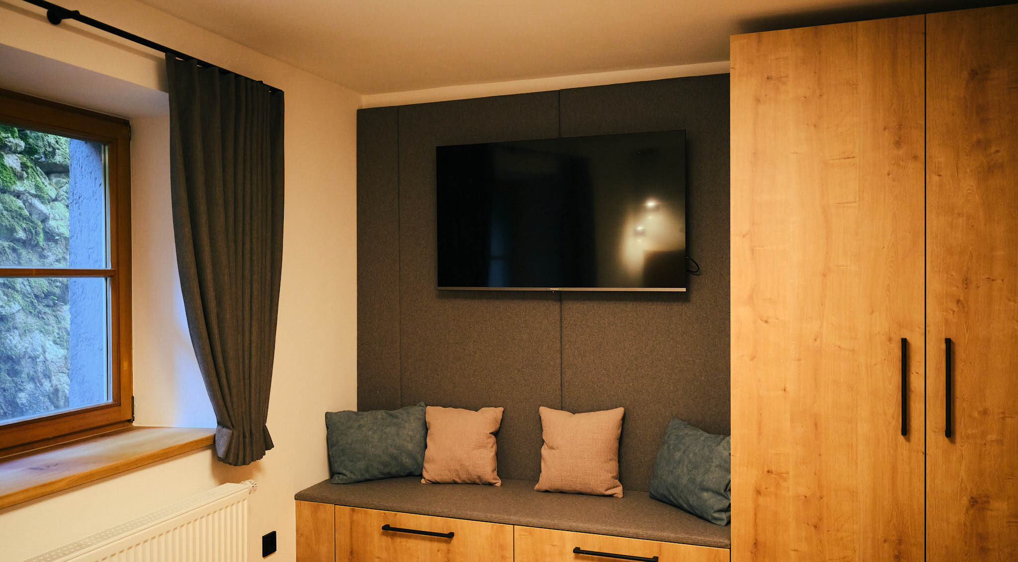 Blick auf die Schränke und den Fernseher im Schlafzimmer des Neumeier Apartments