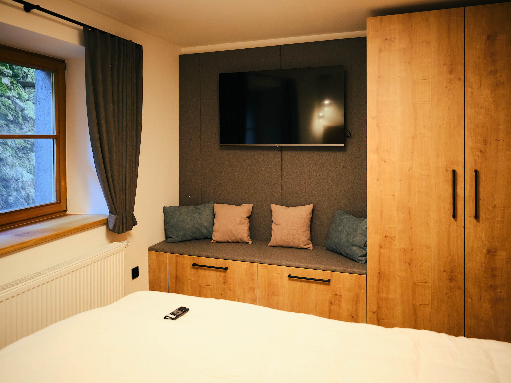 Blick auf die Schränke und den Fernseher im Schlafzimmer des Neumeier Apartments